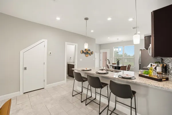 a kitchen with a dining table chairs and white stainless steel appliances