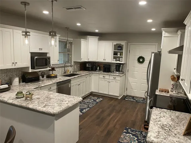 a kitchen with a sink appliances and cabinets