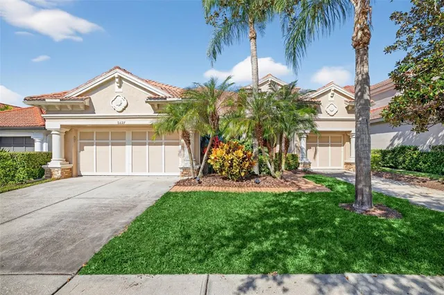 a view of a house with a yard and palm trees