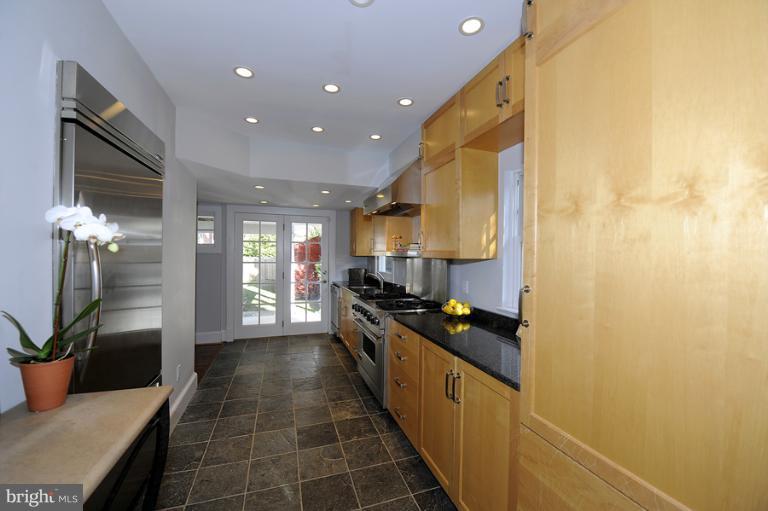a kitchen with stainless steel appliances a sink a stove top oven a counter space and cabinets