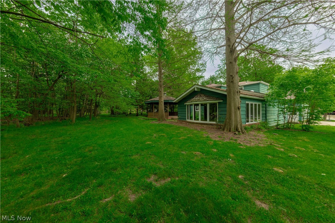 25001 Letchworth Road Beachwood, OH 44122 - Photo 45 of 50 Expansive green lawn with mature trees and a teal-sided residence featuring multiple large windows