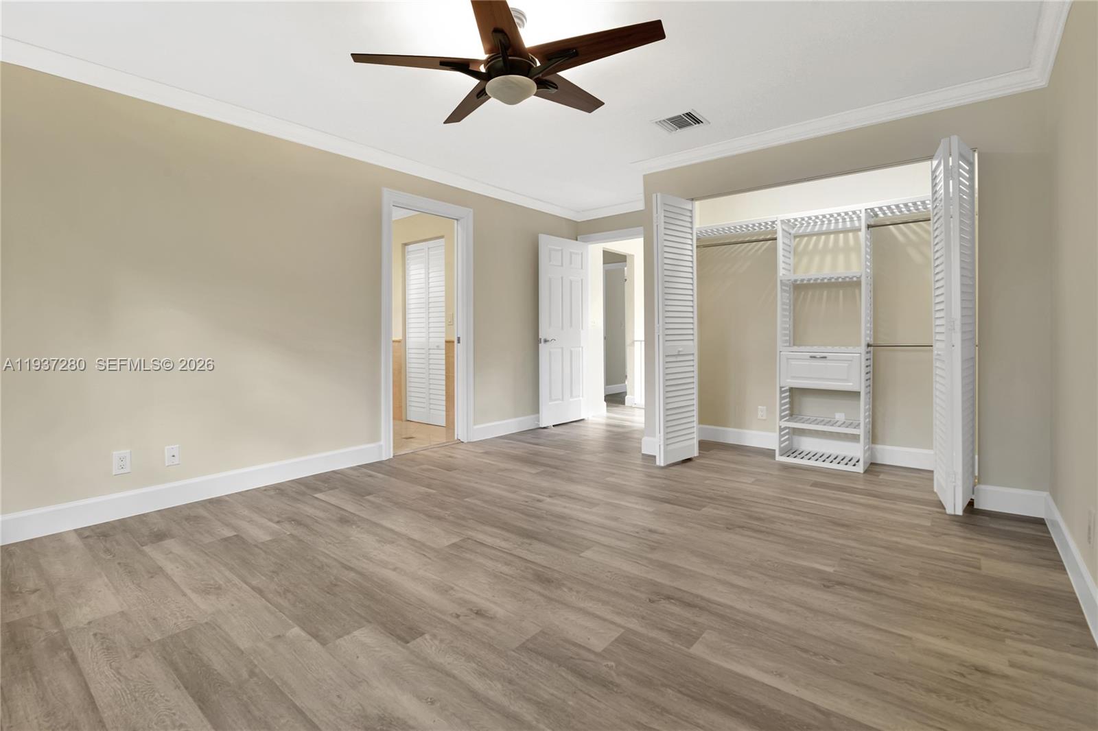 3114 Kingswood Terrace Boca Raton, FL 33431 - Photo 22 of 40 an empty room with wooden floor and windows
