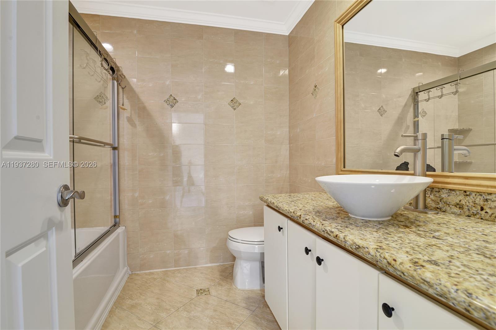 3114 Kingswood Terrace Boca Raton, FL 33431 - Photo 27 of 40 a bathroom with a granite countertop sink a toilet a mirror and shower