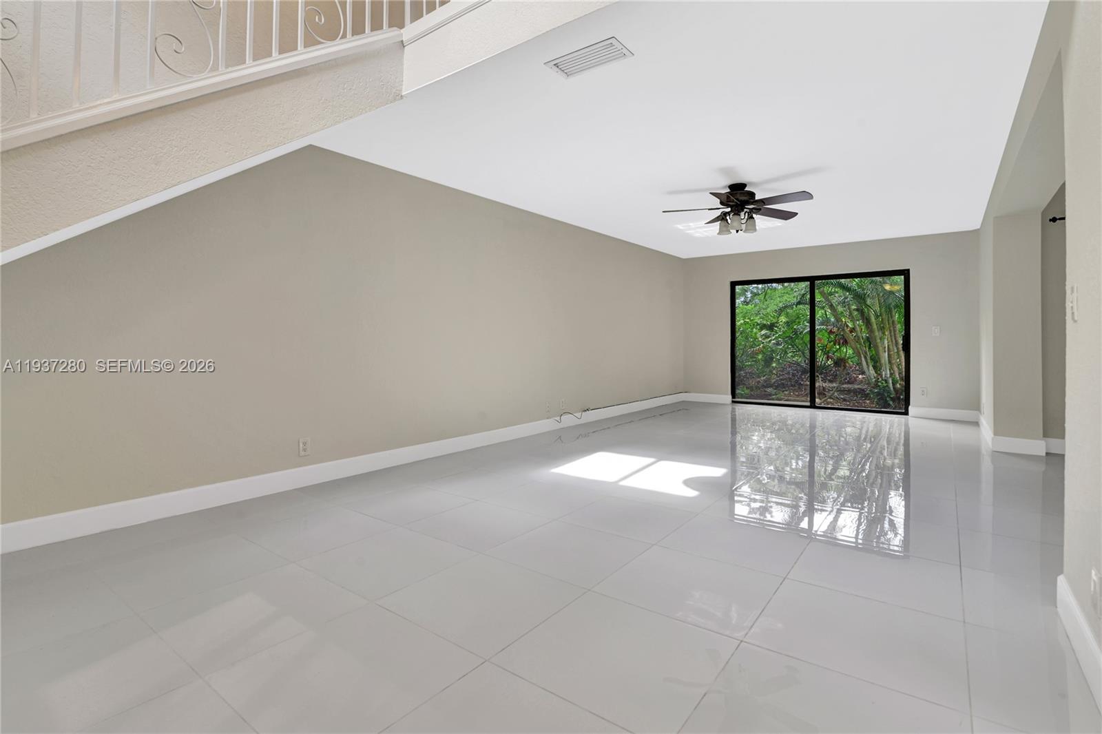 3114 Kingswood Terrace Boca Raton, FL 33431 - Photo 8 of 40 an empty room with windows and view of kitchen