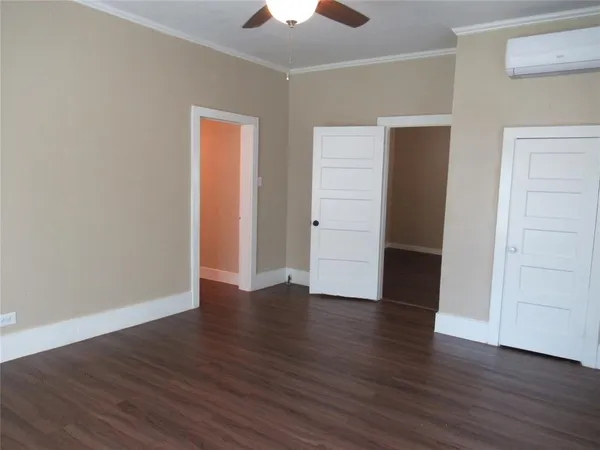 an empty room with wooden floor and closet