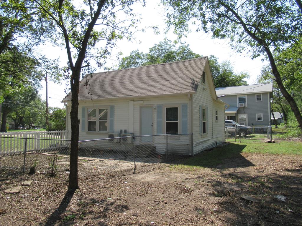 1402 Walnut Street Commerce, TX 75428 - Photo 9 of 11 a view of a house with a yard and large tree