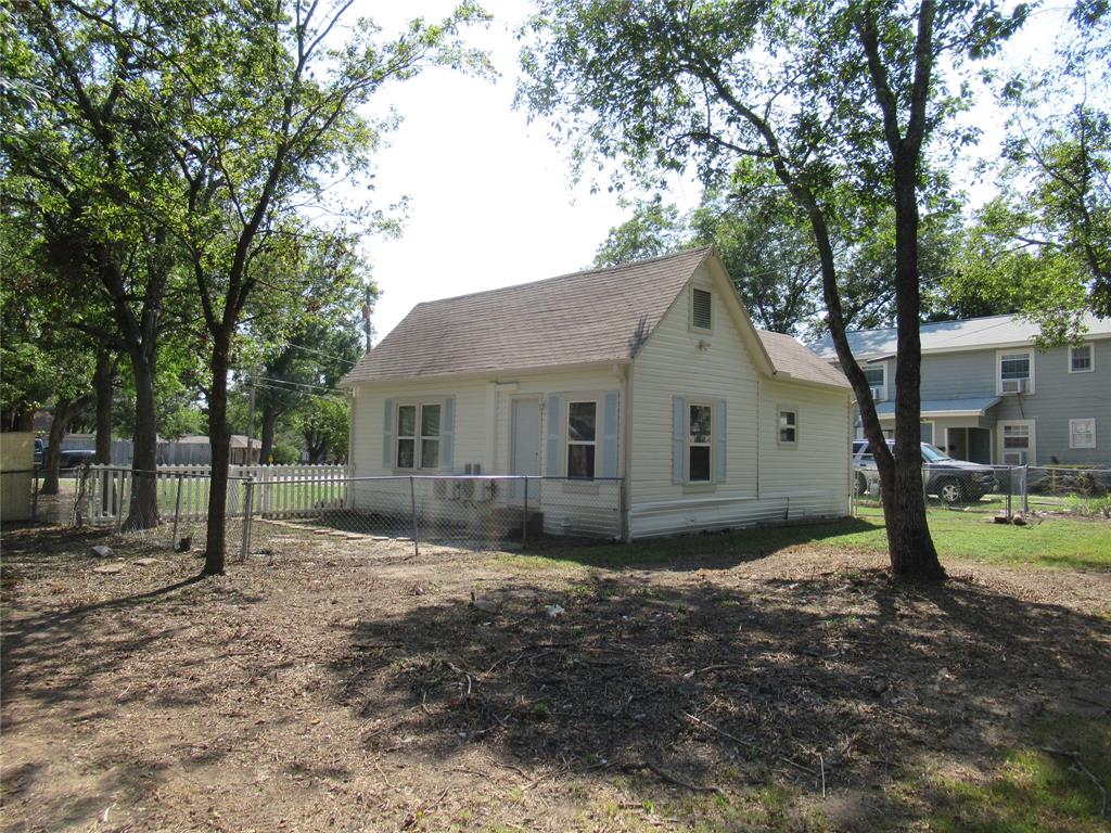 1402 Walnut Street Commerce, TX 75428 - Photo 10 of 11 a front view of a house with a yard