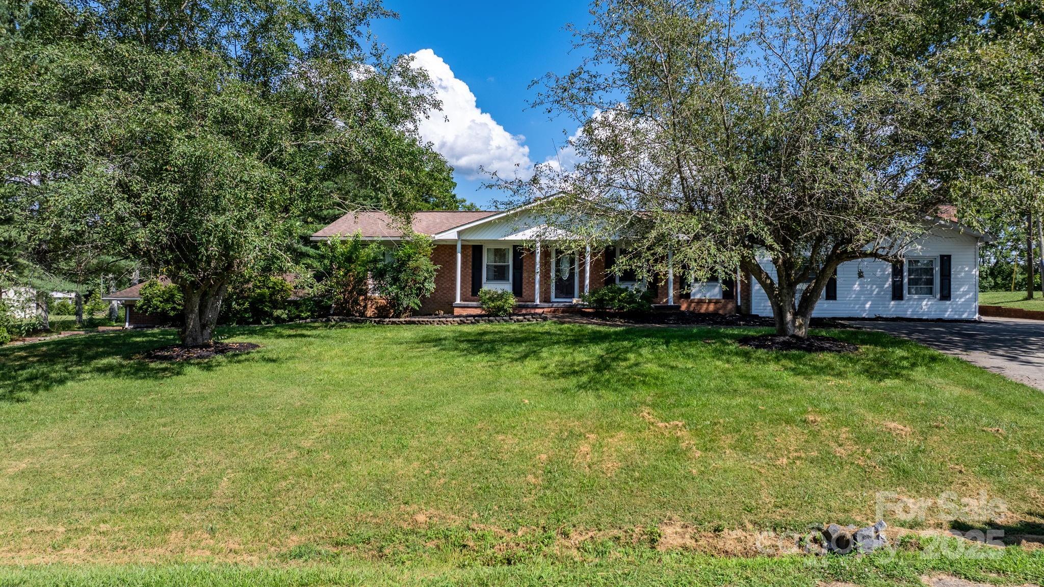2596 Sweetbriar Circle Lenoir, NC 28645 - Photo 25 of 47 a front view of a house with a yard table and chairs