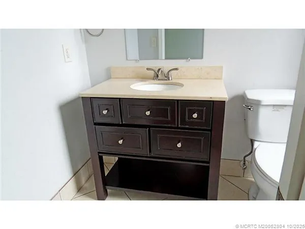 a bathroom with a sink a toilet and a mirror