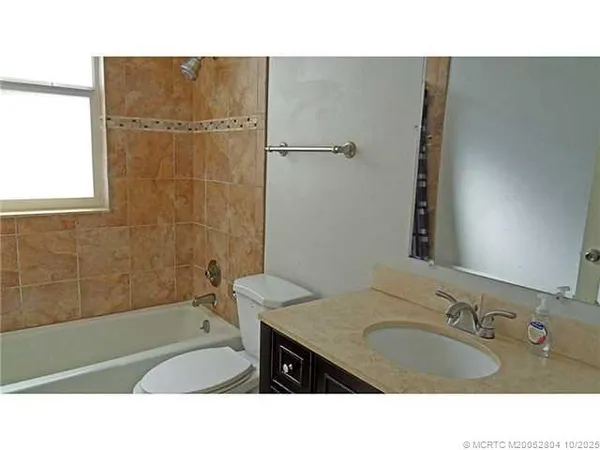 a bathroom with a sink tub shower and a mirror