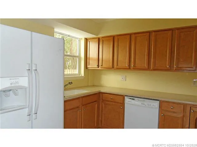 a kitchen with a sink a window and cabinets