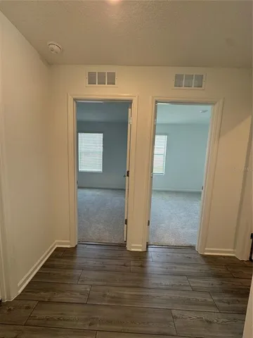 a view of a hallway with wooden floor