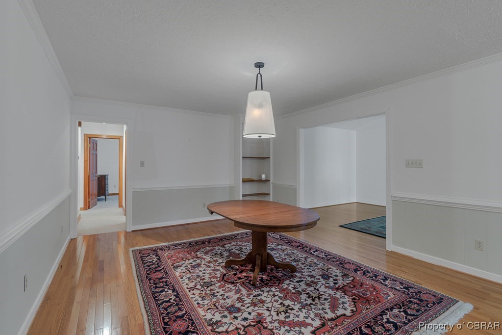 35 Powhatan Road Kilmarnock, VA 22482 - Photo 24 of 42 Dining room with crown molding, light wood-style flooring, and a textured ceiling