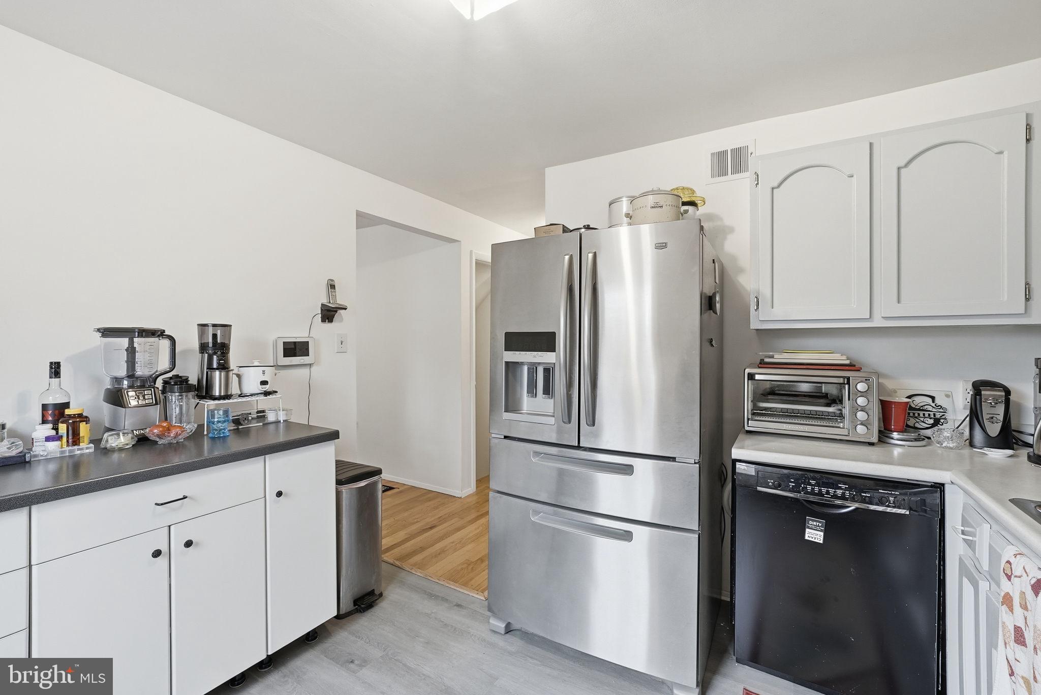 14506 Danville Road Woodbridge, VA 22193 - Photo 11 of 26 a kitchen with cabinets stainless steel appliances and wooden floor