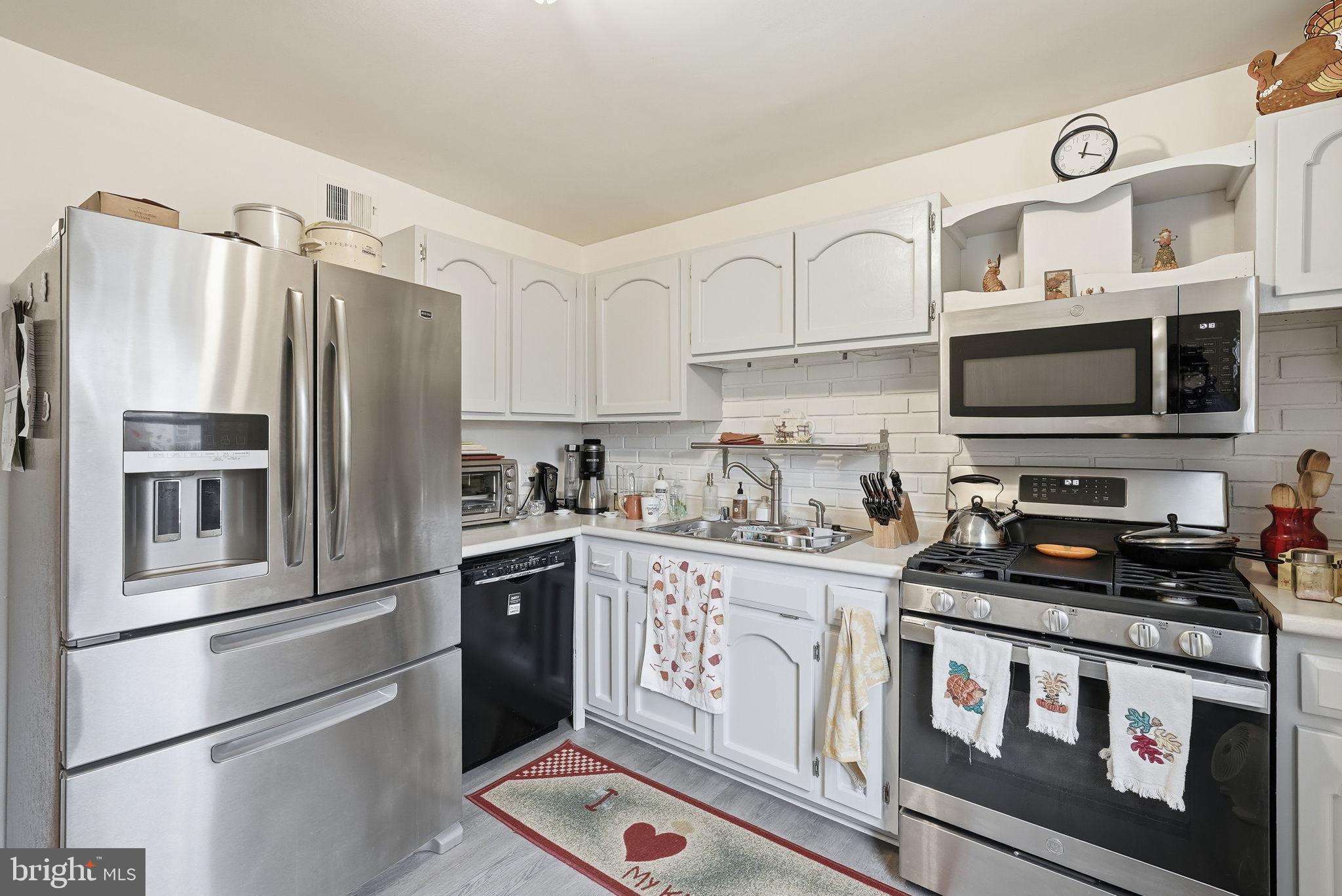 14506 Danville Road Woodbridge, VA 22193 - Photo 12 of 26 a kitchen with stainless steel appliances granite countertop a refrigerator a stove a sink and white cabinets