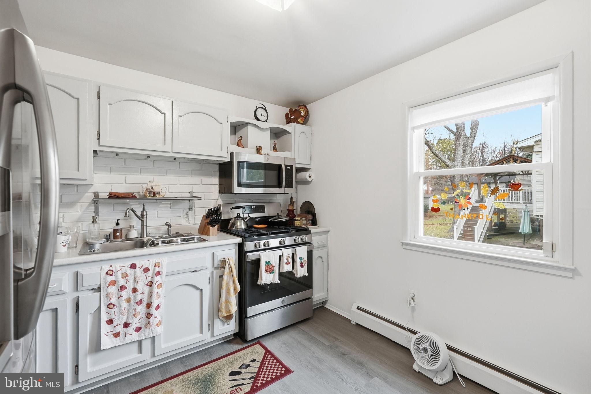 14506 Danville Road Woodbridge, VA 22193 - Photo 10 of 26 a kitchen with stainless steel appliances granite countertop a stove a sink dishwasher and cabinets with wooden floor