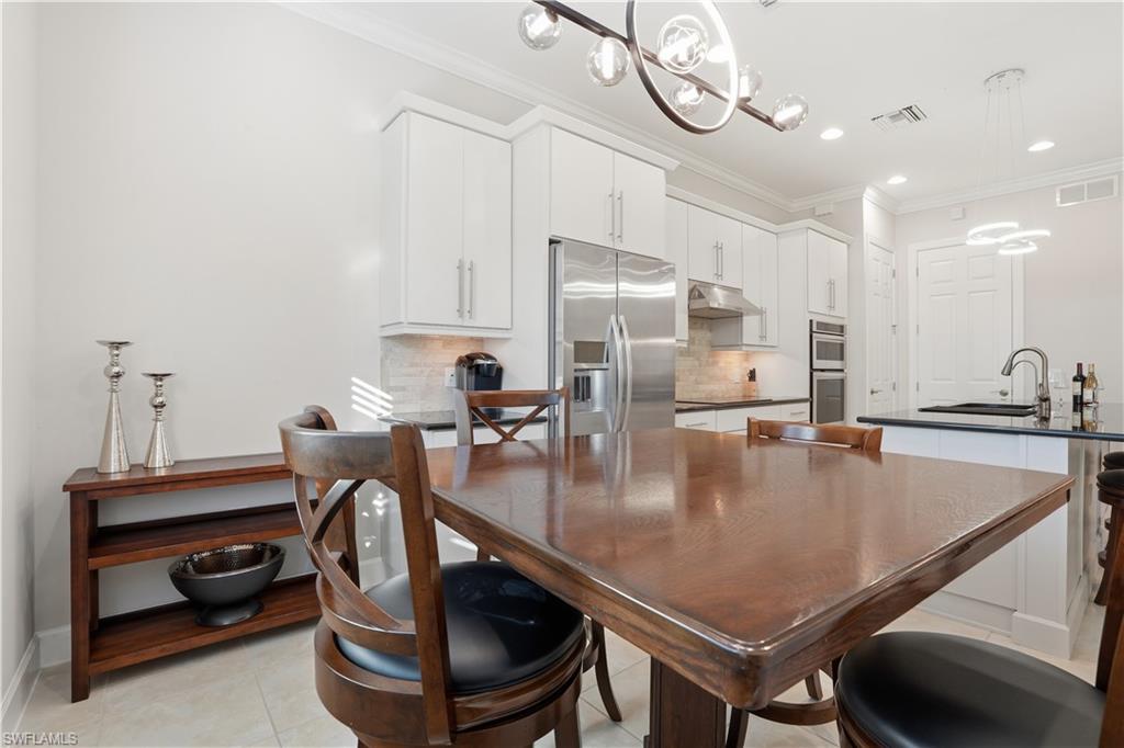 9328 Fieldstone Lane Naples, FL 34120 - Photo 13 of 40 a kitchen with stainless steel appliances granite countertop a sink a stove and a table