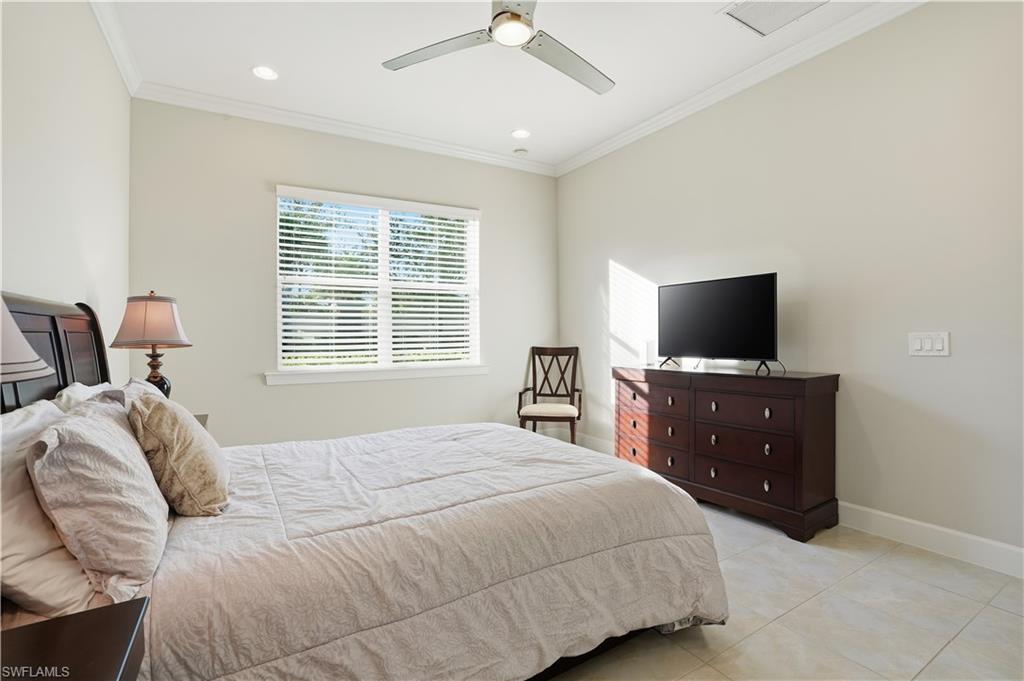 9328 Fieldstone Lane Naples, FL 34120 - Photo 14 of 40 a bedroom with a bed and a flat tv screen on dresser