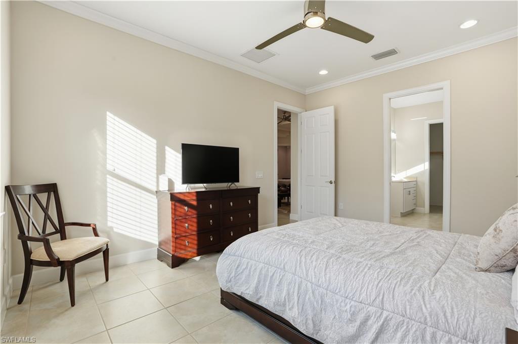 9328 Fieldstone Lane Naples, FL 34120 - Photo 15 of 40 a bedroom with a bed and a flat screen tv