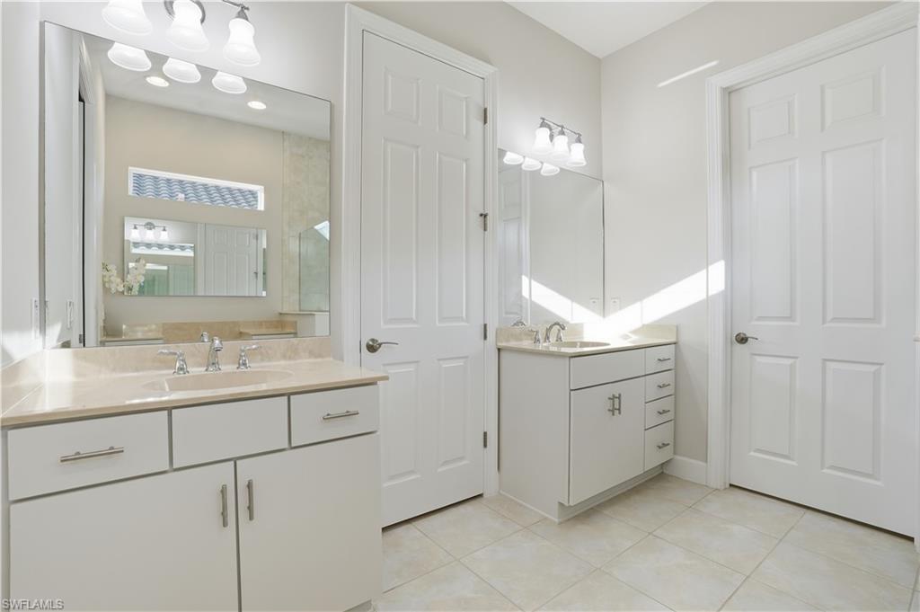 9328 Fieldstone Lane Naples, FL 34120 - Photo 17 of 40 a bathroom with a sink and a mirror