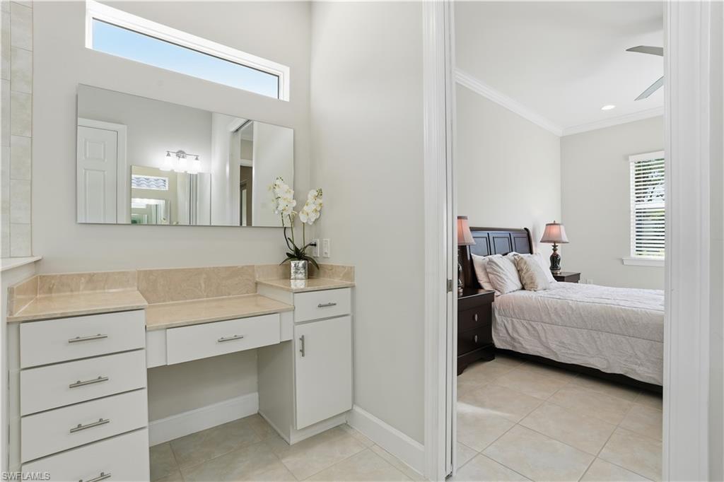 9328 Fieldstone Lane Naples, FL 34120 - Photo 18 of 40 a room with a bed and a dresser in it