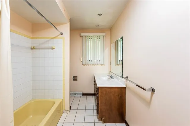 a bathroom with a tub sink and mirror