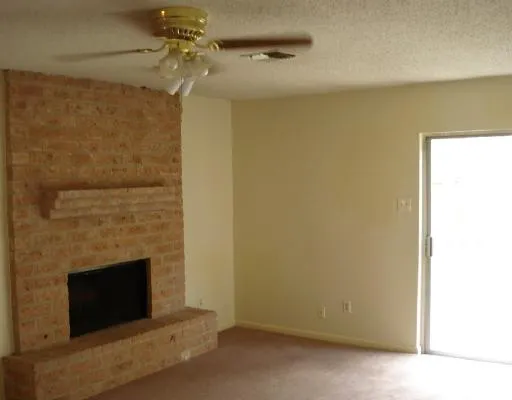 a living room with a fireplace and a ceiling fan