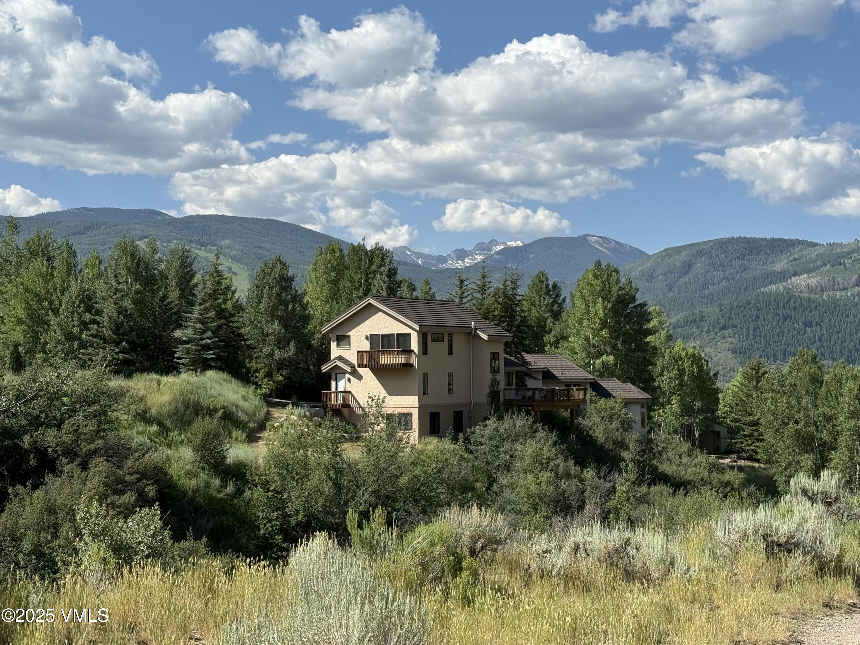 a view of a house with a yard and mountains