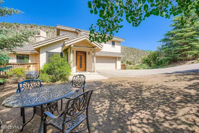 a view of a house with backyard and sitting area