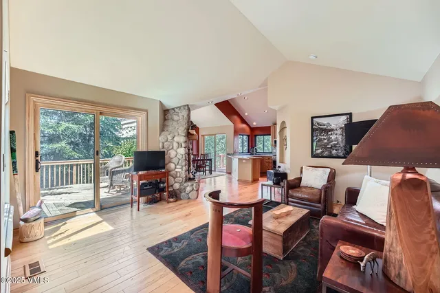 a living room with furniture a flat screen tv and a floor to ceiling window