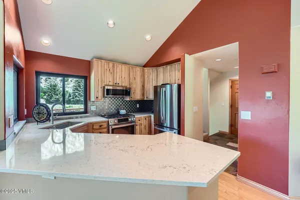 a kitchen with stainless steel appliances granite countertop a sink refrigerator and microwave