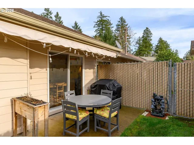 a backyard of a house with table and chairs