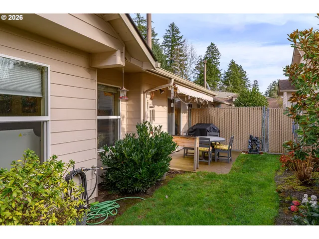 a view of a chair and table in backyard of the house