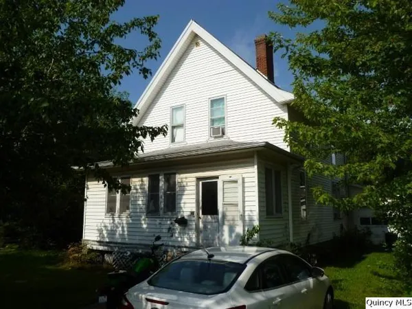 a front view of a house with yard and green space