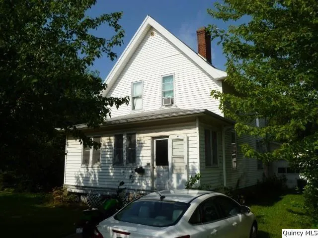 a front view of a house with yard and green space