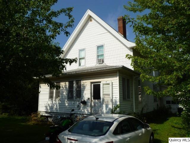 a front view of a house with yard and green space