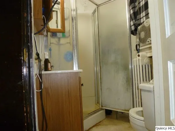 a bathroom with a granite countertop sink a toilet and shower