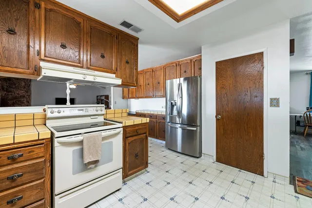 a kitchen with stainless steel appliances granite countertop a refrigerator stove and cabinets