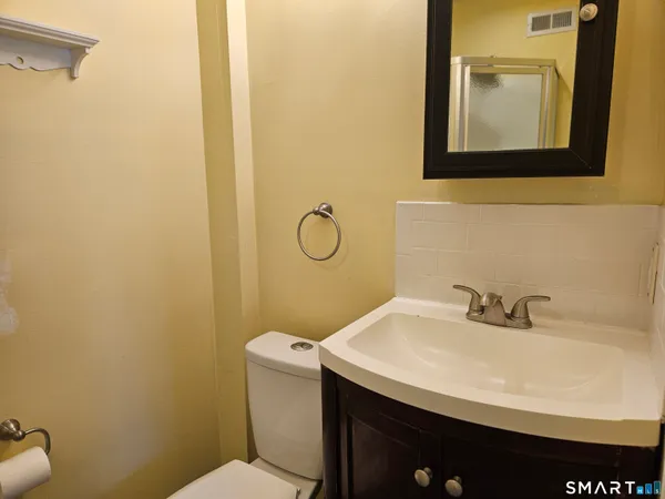 a bathroom with a sink a toilet and mirror