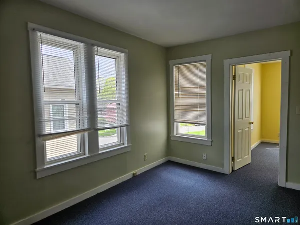 an empty room with windows and closet