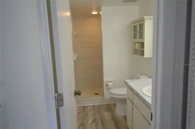 a bathroom with a granite countertop toilet and a shower