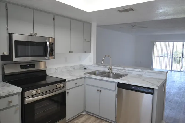 a kitchen with a sink stove and microwave