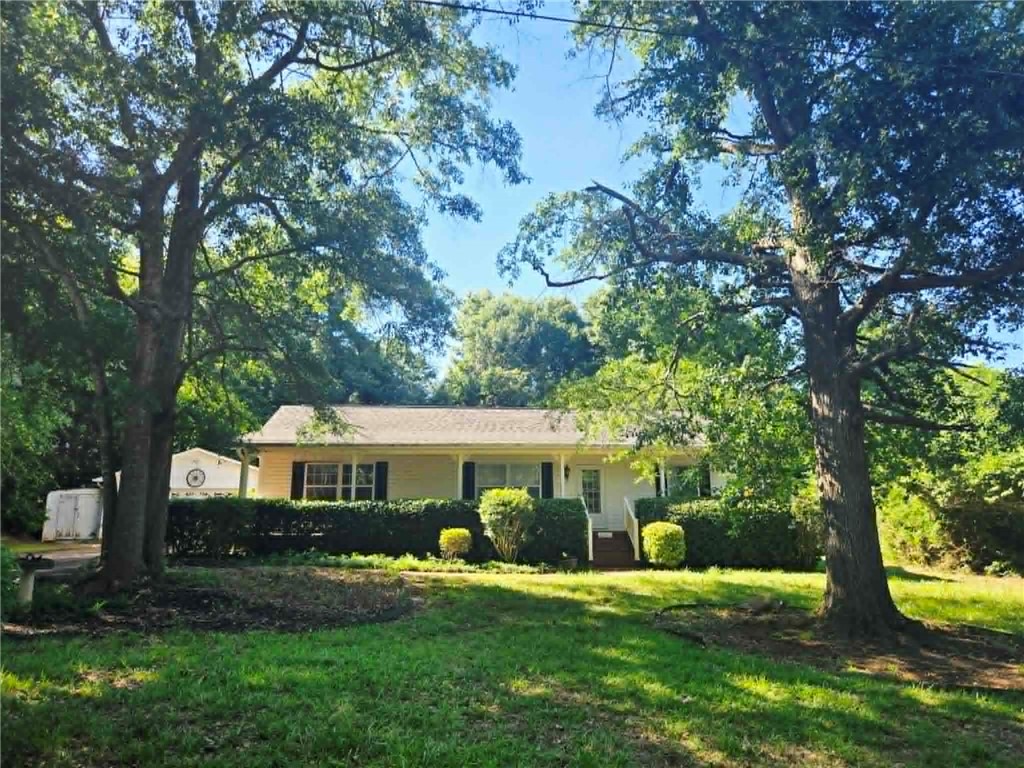A classic ranch home nestled among mature trees offers serene outdoor living.