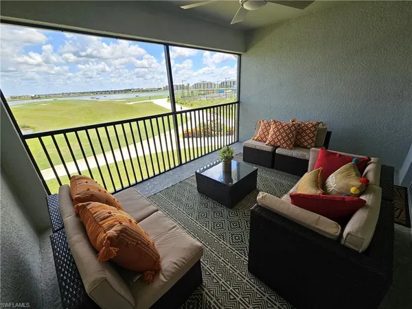a living room with furniture and a floor to ceiling window