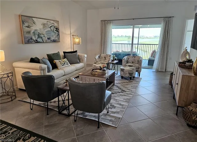 a living room with furniture a large window and a rug