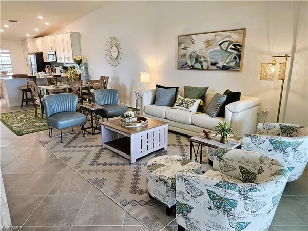 a kitchen with stainless steel appliances granite countertop a sink a stove a refrigerator a microwave a dining table and chairs