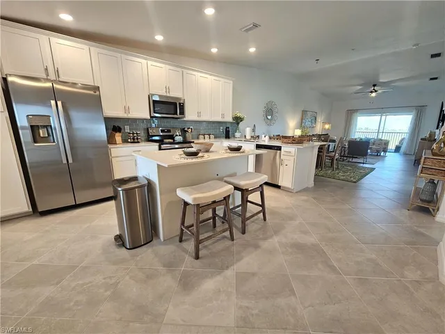 a kitchen with a table chairs microwave and cabinets