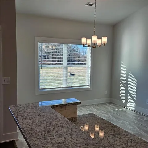 a kitchen area with granite countertop a stove a sink and a window