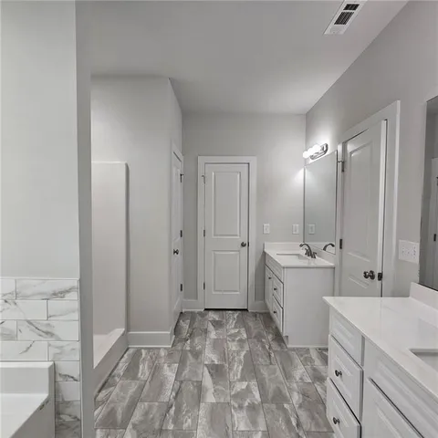 a large white bathroom with a sink mirror and a bathtub