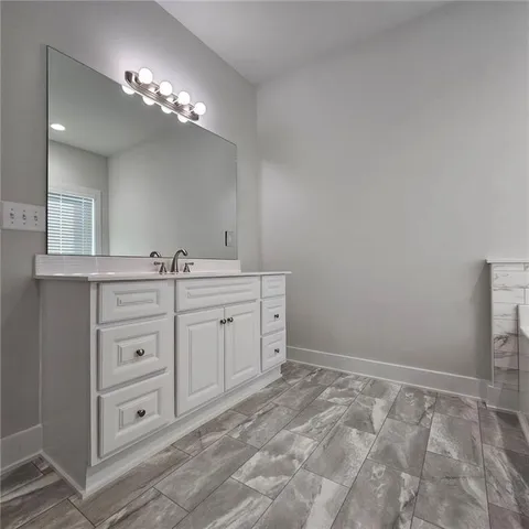 a spacious bathroom with a double vanity sink and a mirror